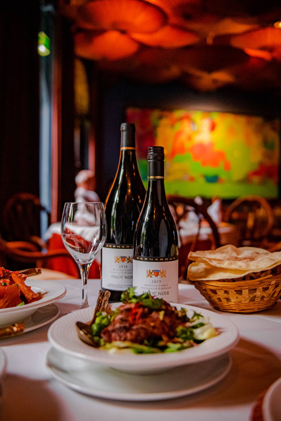 Gedekte tafel met wijn en een gerecht in een sfeervol restaurant